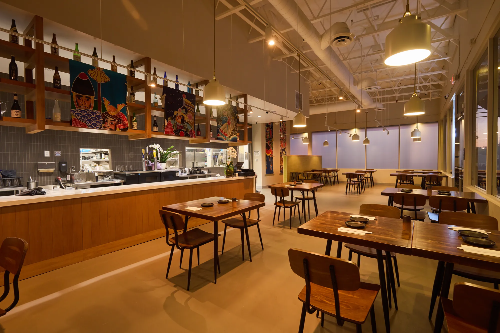 Open dining room, blonde wood, folk-art banners